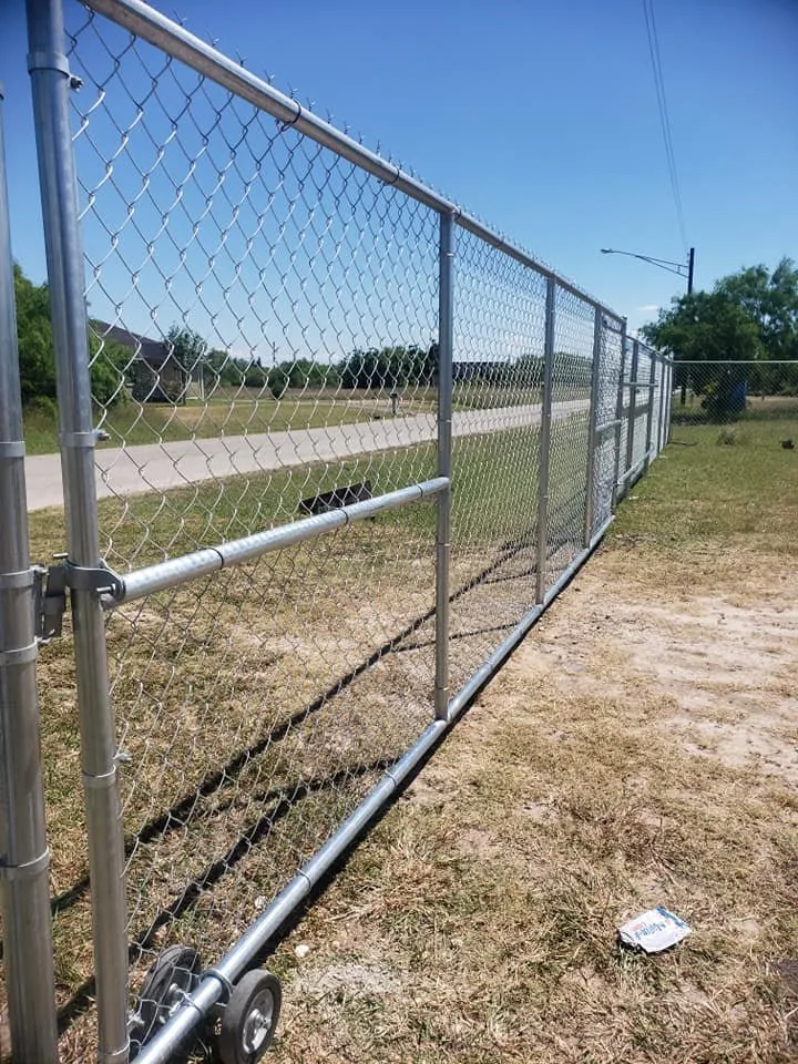 A chain-link fence with a wide access gate